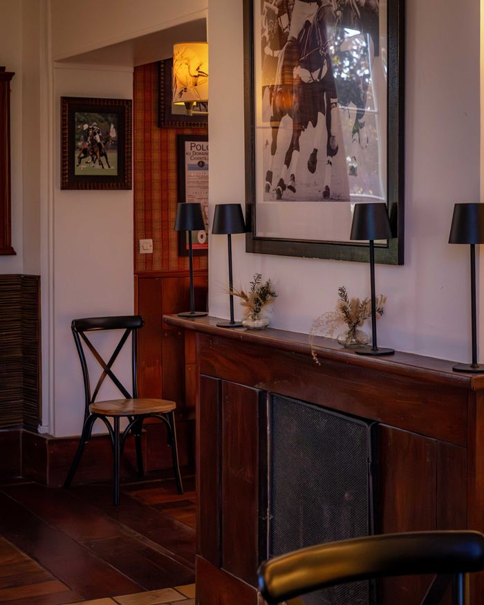 Le salon du club-house, sa cheminée et ses photos de polo