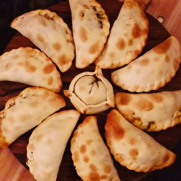 Empanadas dorées disposées en rosace sur une planche