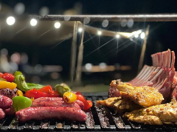 Saucisses, poivrons, poulet et carré d’agneau sur la parrilla, le soir