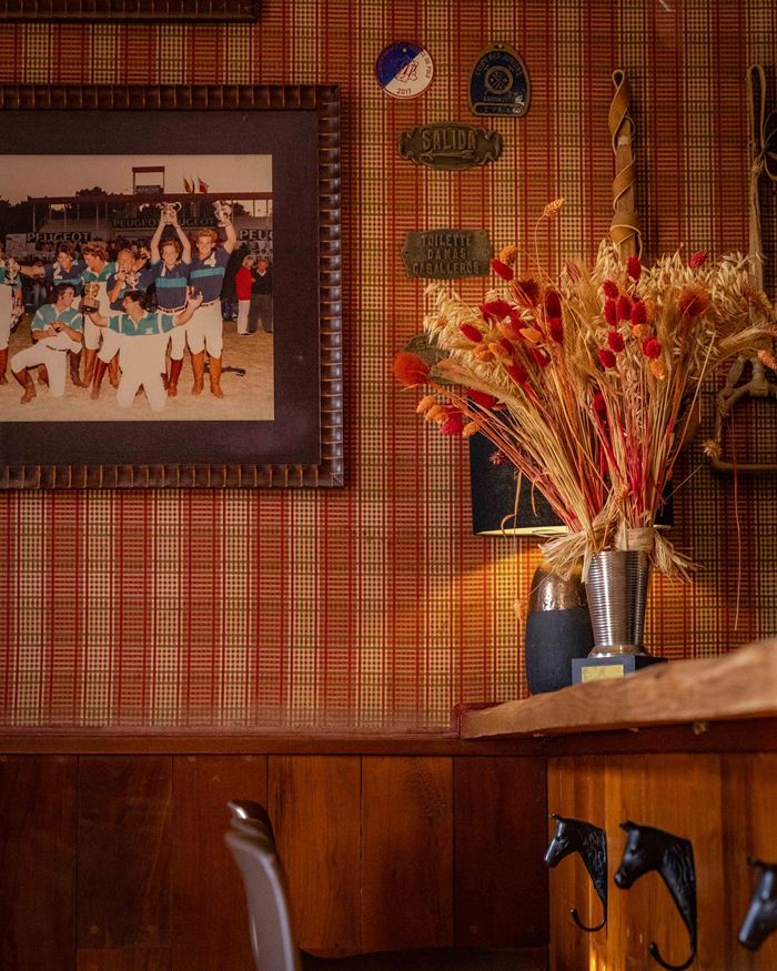Le bar au mur tartan, avec une photo d’équipe de polo et un bouquet de fleurs séchées
